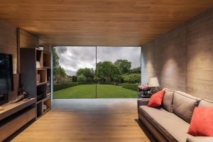 interior shot of modern lounge with black sliding doors looking out to garden