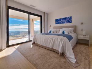 interior shot of bedroom with black aluminium sliding door leading out to a balcony