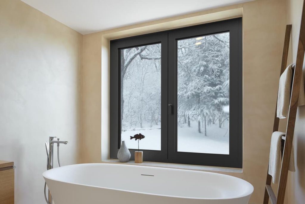 Black COR 80 Aluminium window in a modern bathroom with a snowy view outside.